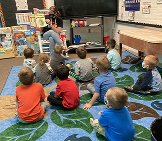 preschool aged students listening to teacher read
