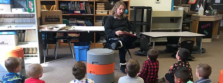 teacher reading book to group of students