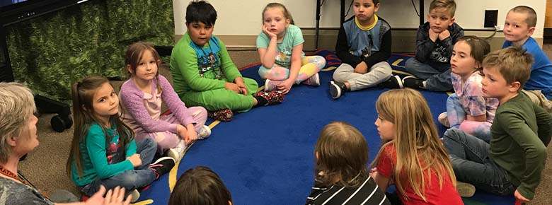 students sitting in circle on carpet